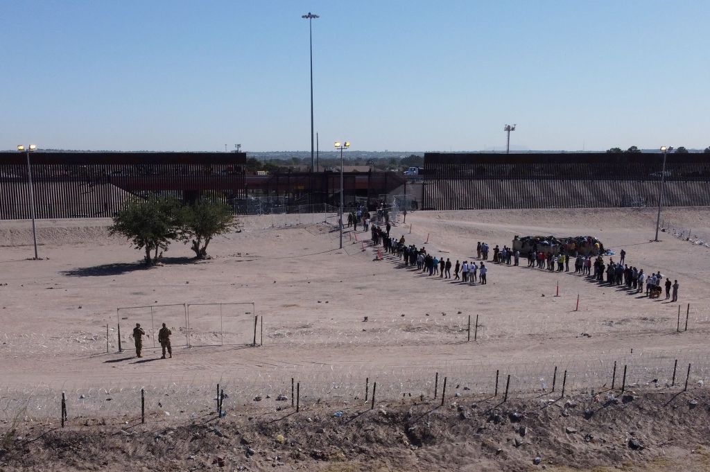 Migrants line up to be processed at the US-Mexico border